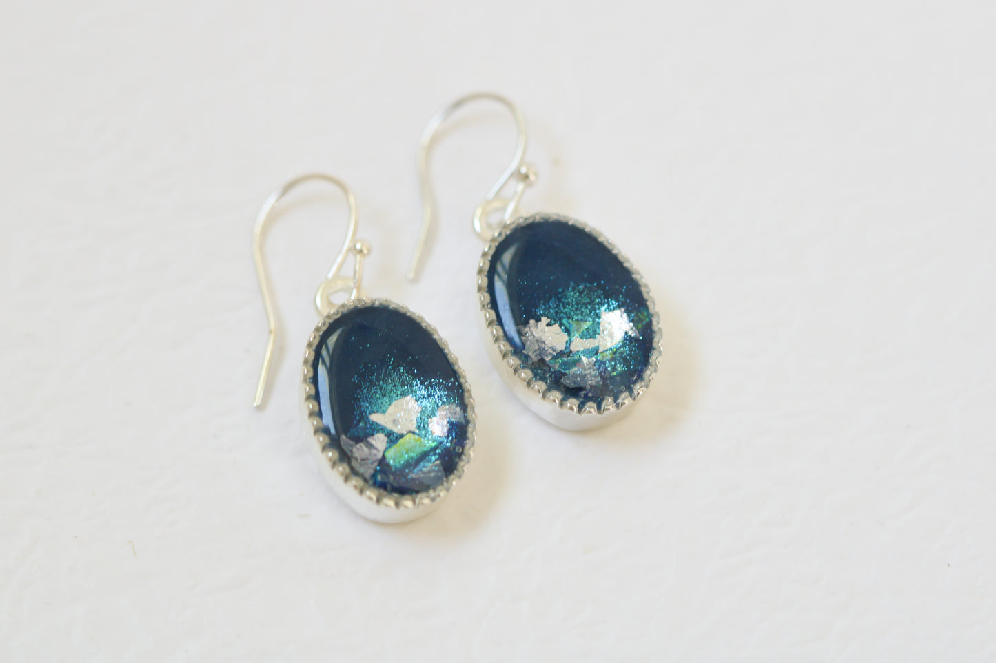 pair of handmade resin and clay blue and silver oval dangle earrings