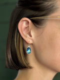 model wearing blue and silver resin and clay oval dangle earrings