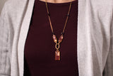 model wearing gold and burgundy dressy necklace with garnets