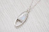 Silver oval shaped necklace with sparkle on white background
