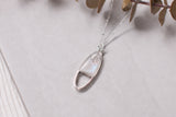 Silver oval shaped necklace with sparkle on white background