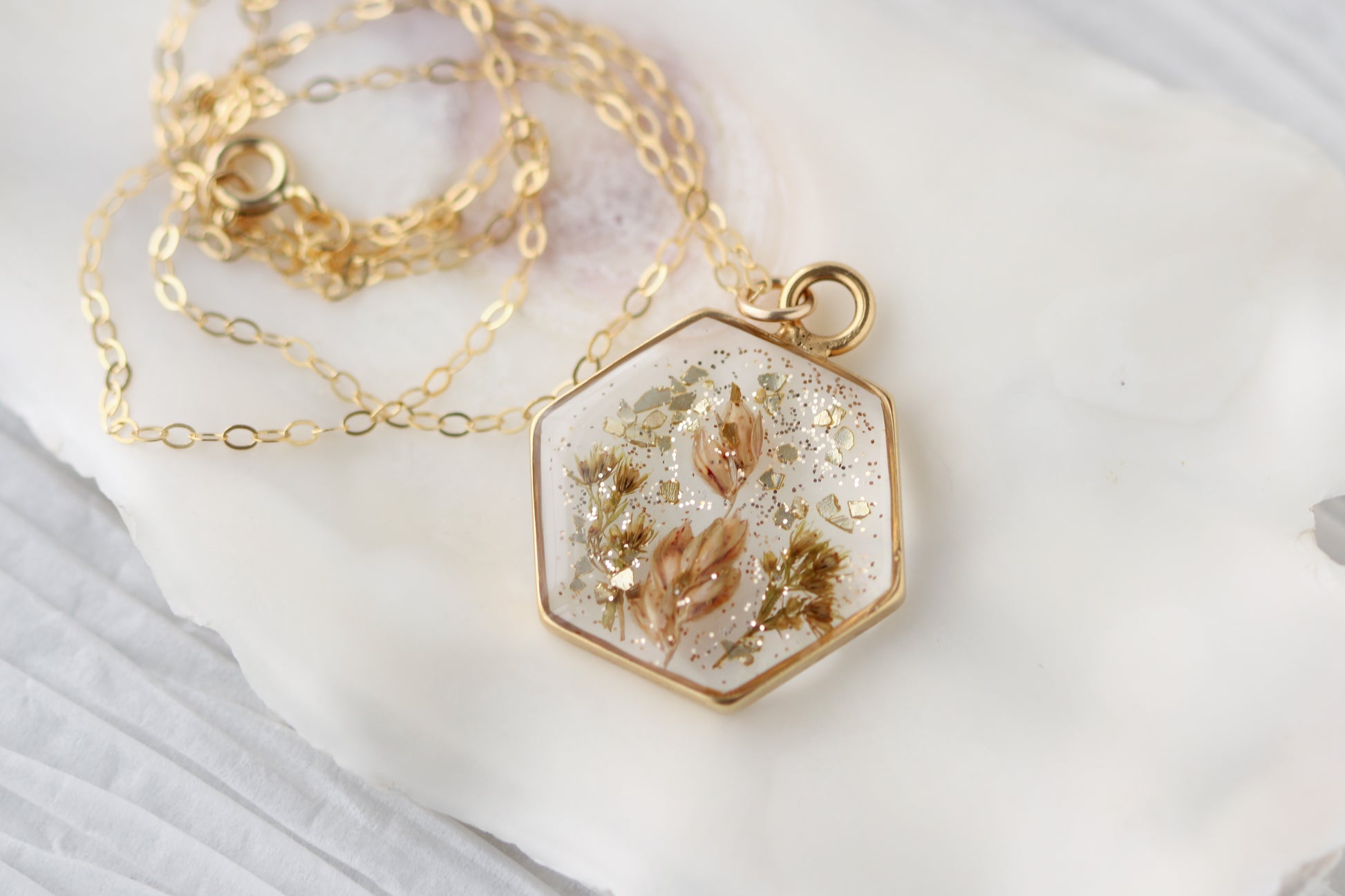 handmade resin and dried flower hexagon shaped necklace in gold with glitter