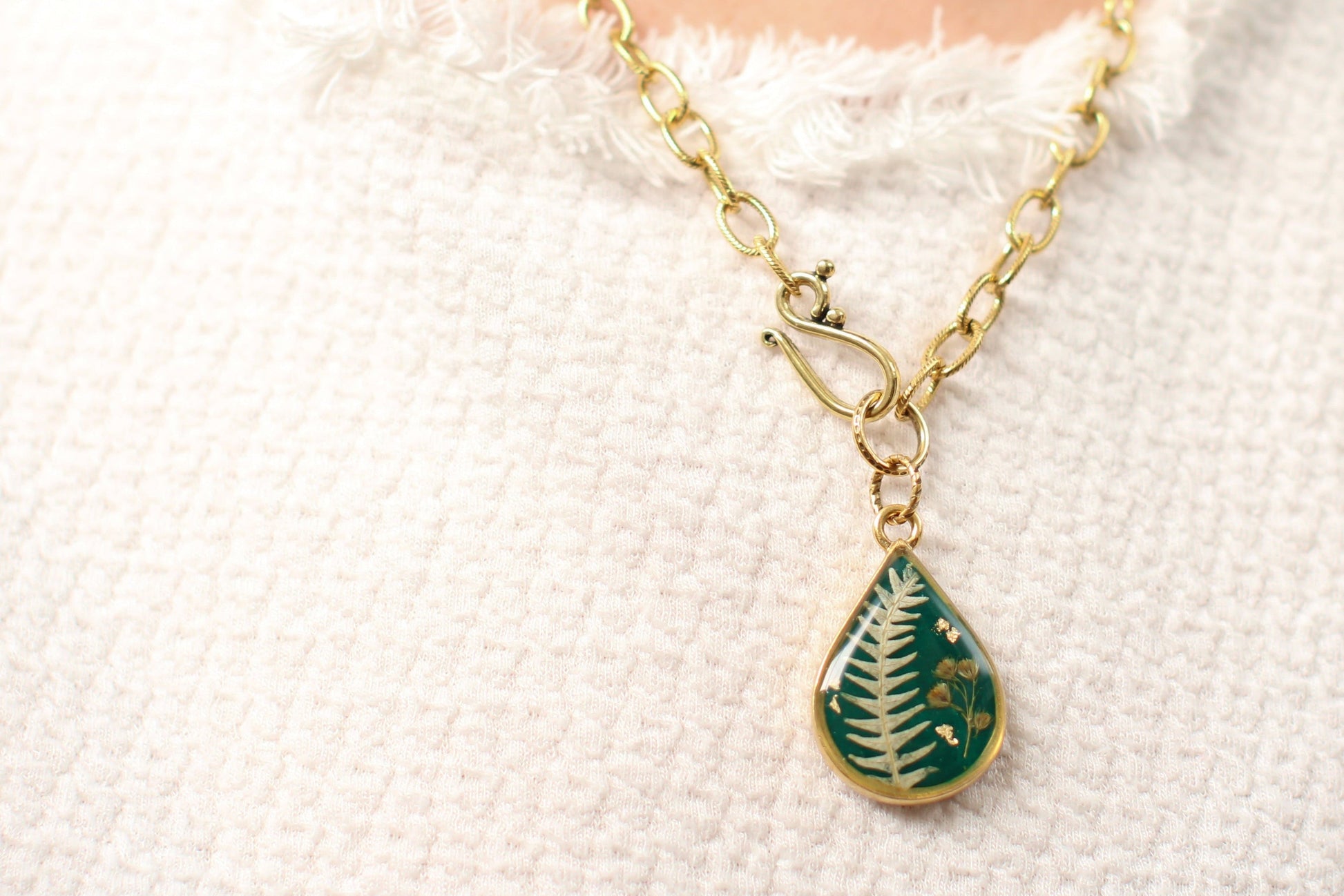 Handmade Botanical Resin and Clay Necklace worn on a model with a white shirt